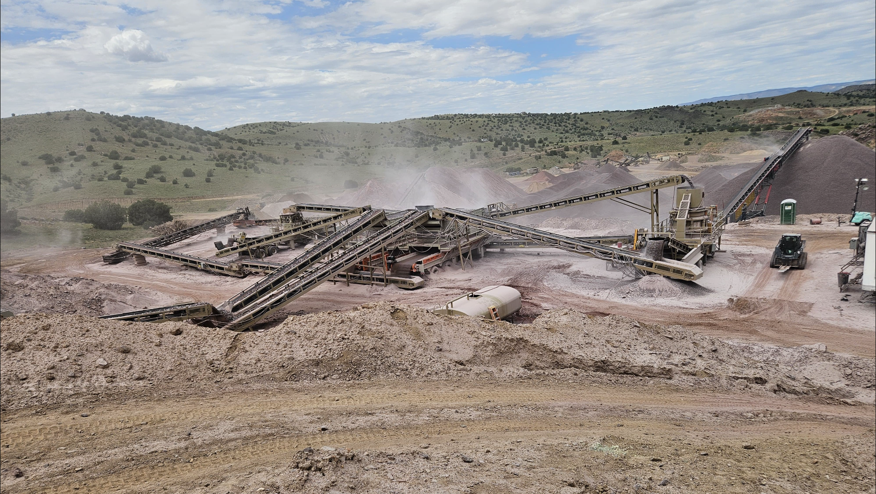 Multi-stage Onyx contract crushing plant — full conveyor stack, screens, and stockpiles operating on a customer site