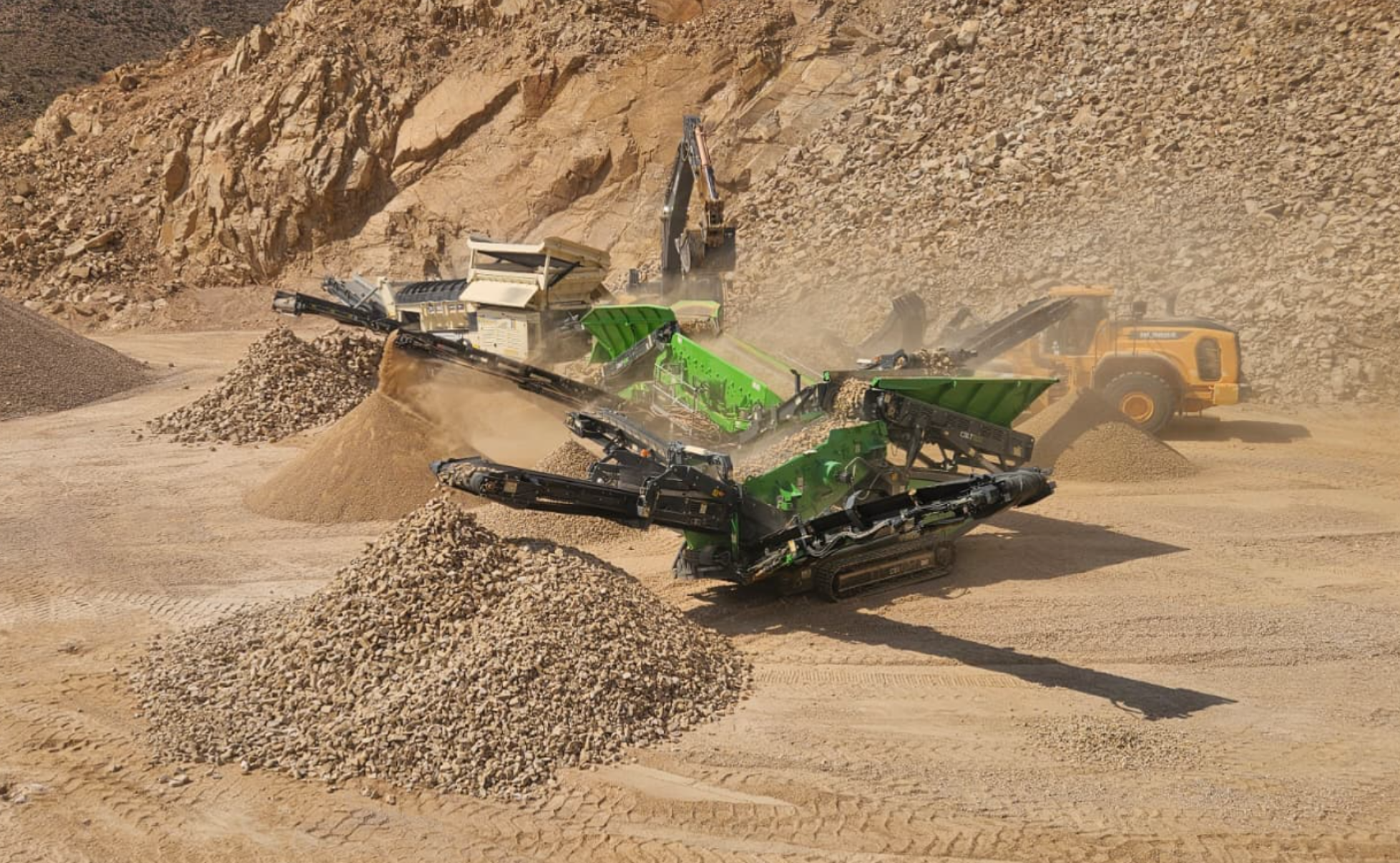 Onyx mobile impactor crushing in an Arizona quarry pit, sized aggregate piles in foreground